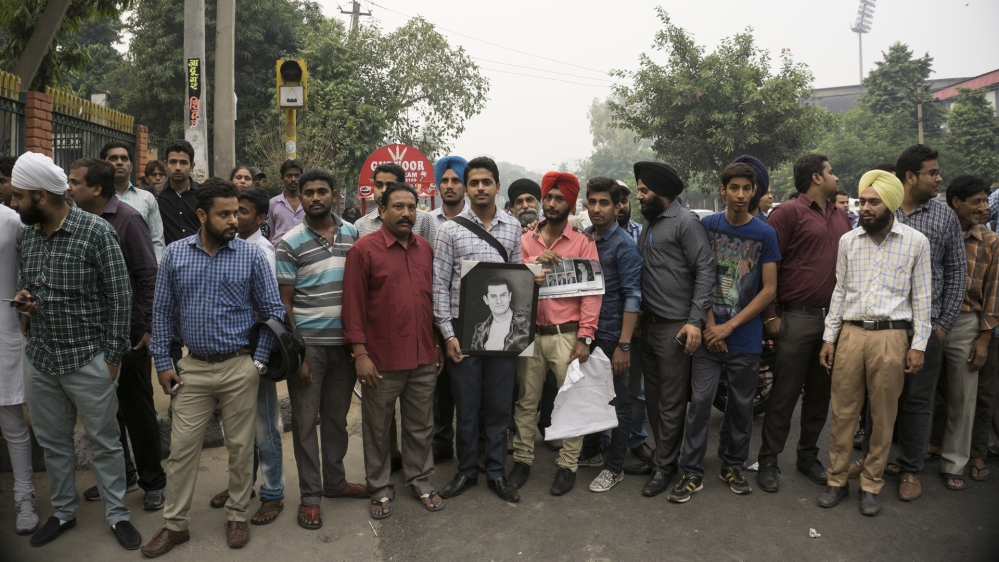 Aamir Khan fans are holding a portrait of the superstar. Bollywood stars in India enjoy God-like status [Al Jazeera]