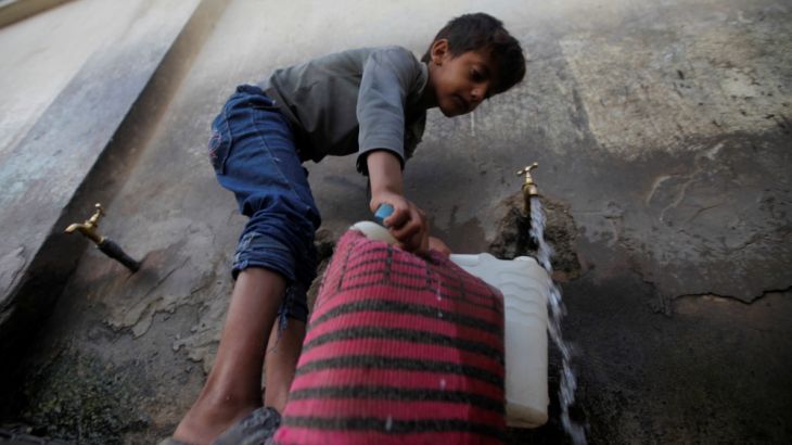 A boy fills up a water container from a public tap, amid a cholera outbreak, in Sanaa