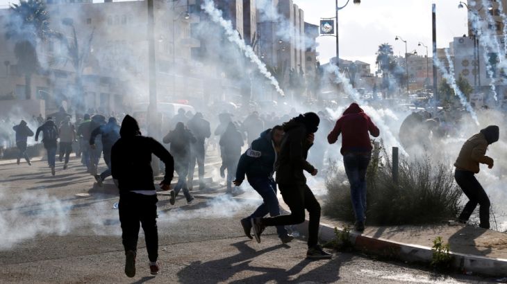 Palestinian protesters run from tear gas fired by Israeli troops during clashes at a protest against U.S. President Donald Trump''s decision to recognize Jerusalem as the capital of Israel