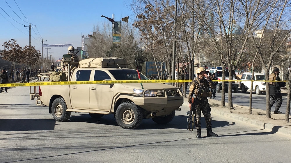 Afghan security forces stand guard near the site of the blasts [Shah Marai/AFP]