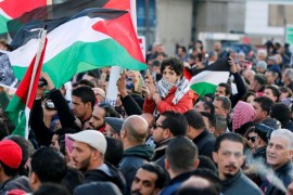Protesters hold the Palestinian flags during a protest near the American Embassy in Amman