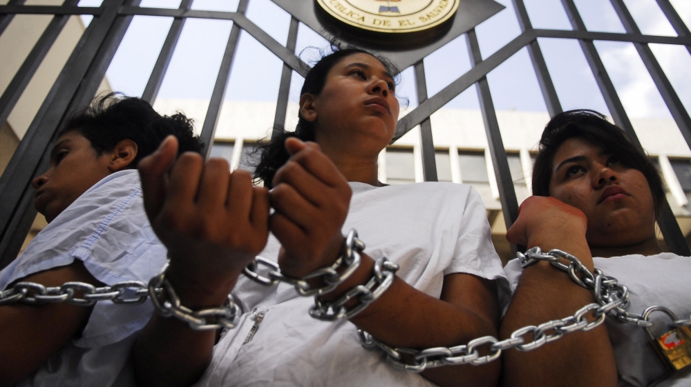 Women stand chained together outside the Supreme Court during a protest in San Salvador  [Reuters] 