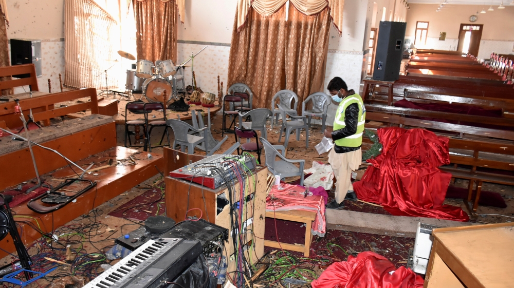 A forensic team member collects evidence amidst the damage after gunmen attacked the Bethel Memorial Methodist Church in Quetta [Naseer Ahmed/Reuters]