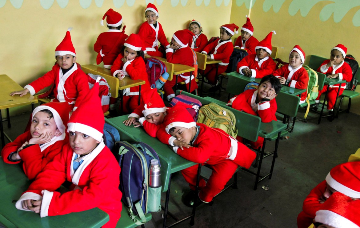 Children dressed in Santa Claus costumes sit inside a classroom before participating in Christmas celebrations at a school in Chandigarh, India, December 20, 2017. REUTERS/Ajay Verma TPX IMAGES OF THE