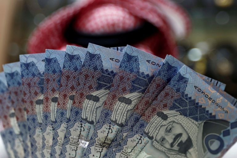 Saudi money changer displays Saudi Riyal banknotes at a currency exchange shop in Riyadh