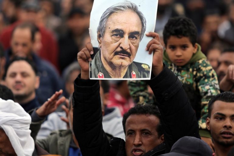 A man holds a poster of Eastern Libyan military commander Khalifa Haftar during a rally in Benghazi