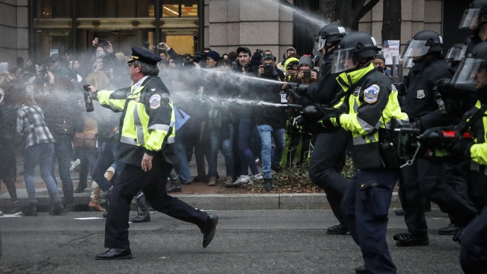 Police fire pepper spray on protesters during a demonstration after Trump's inauguration [File: John Minchillo/AP Photo] 