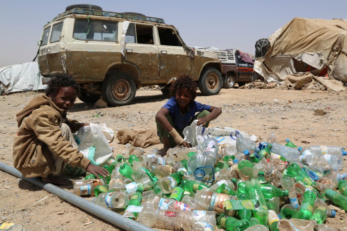 In this settlement outside Houth, nine-year-old Obaid (left) and his friend Modrek collect empty plastic bottles to sell for recycling. “If we collect one full, large bag, we get 150 Yemeni Rials (US