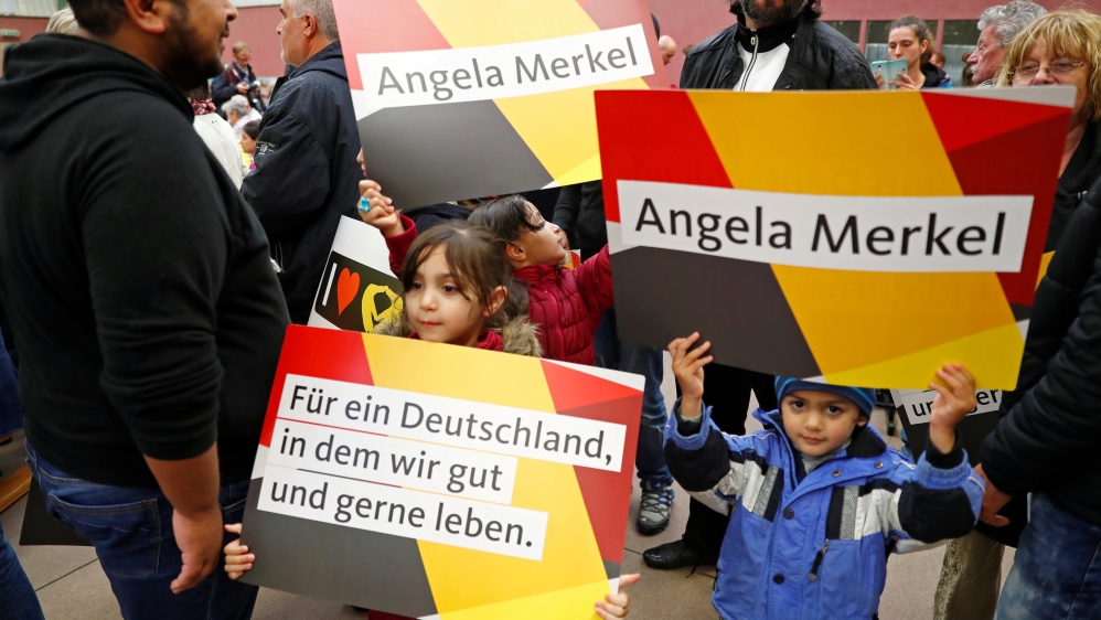 Syrian refugees and their children attend an election campaign rally of German Chancellor Angela Merkel in September [File: Fabrizio Bensch/Reuters]