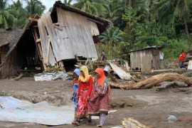 Residents walk in a village devastated by flashfloods in Salvador, Lanao del Norte