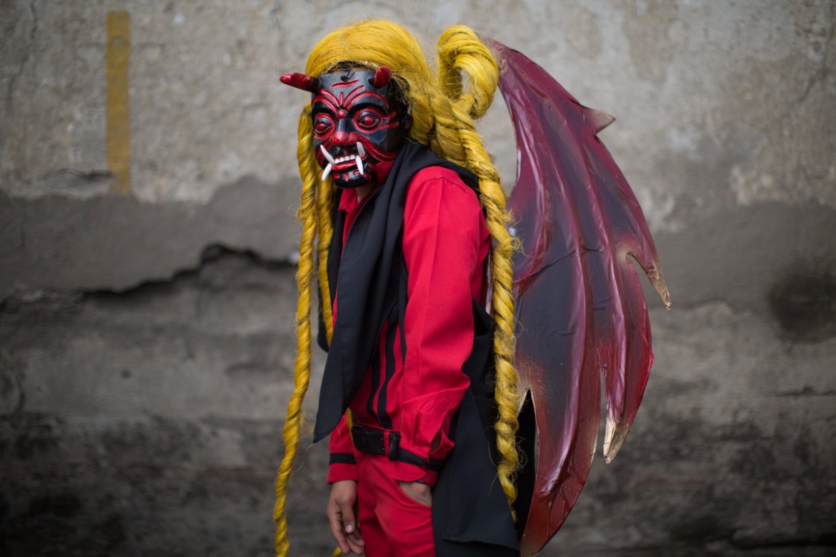 Bryan Gonzalez, 14, poses for a portrait in his devil costume at a procession symbolising the fight between good and evil that celebrates the Virgin of the Immaculate Conception in Ciudad Vieja, Guate