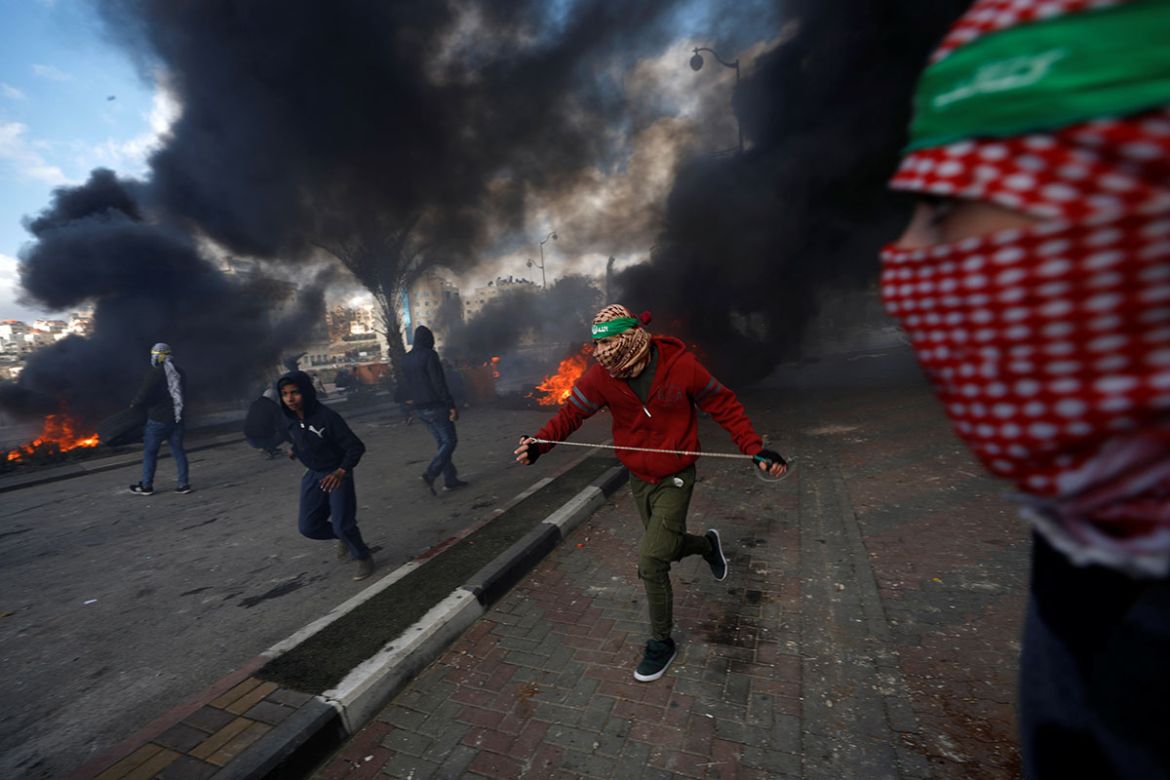 Palestinian protesters run during clashes with Israeli troops at a protest against U.S. President Donald Trump''s decision to recognize Jerusalem as the capital of Israel, near the Jewish settlement of