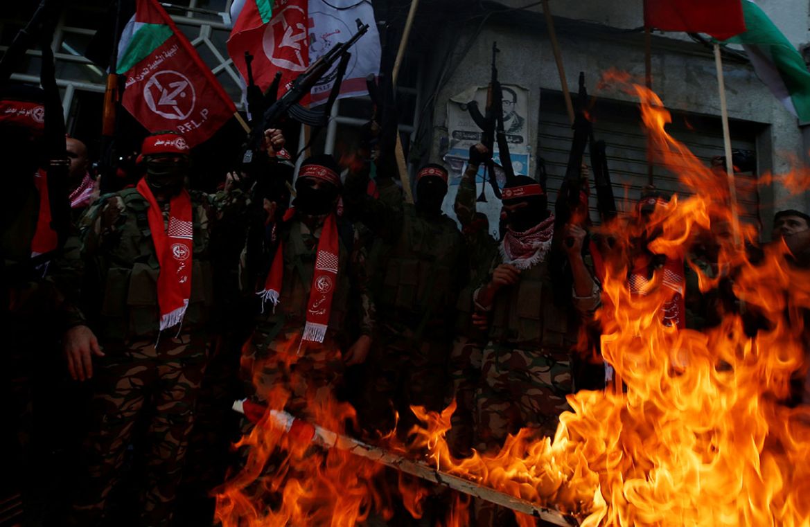Palestinian militants of the Popular Front for the Liberation of Palestine (PFLP) burn representations of an Israeli flag and a U.S. flag during a protest against Trump''s decision to recognize Jerusal
