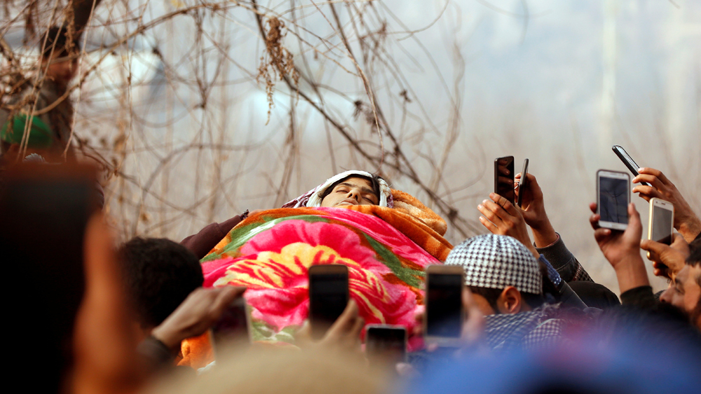 People use their mobile phones to take photographs of the body of Ruby Jan [Danish Ismail/Reuters]
