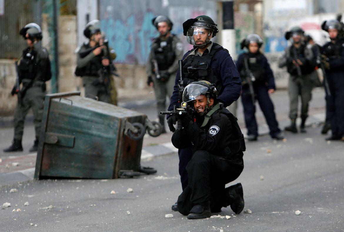 An Israeli policeman aims his weapon during clashes with Palestinians at a protest against U.S. President Donald Trump''s decision to recognize Jerusalem as the capital of Israel, in the West Bank city