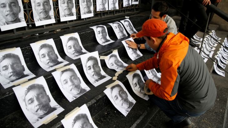 Journalists and a photographer place pictures of reporter Candido Rios, who was killed in Veracruz, during a demonstration against his killing, at the Interior Ministry building in Mexico City