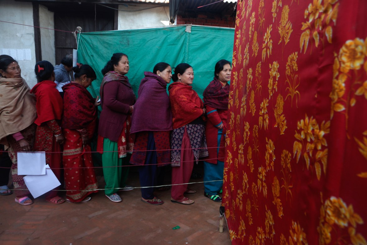 Nepalese women stand and wait on a queue to cast their vote during the legislative elections in Thimi, Bhaktapur, Nepal. Millions of people in Nepal are voting in the final phase of elections for memb