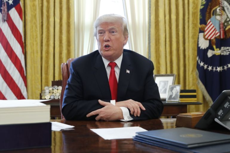 U.S. President Trump sits at his desk before signing tax bill into law at the White House in Washington