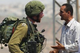 Palestinian man argues with an Israeli soldier during clashes near the West Bank village of Qusra west of Nablus