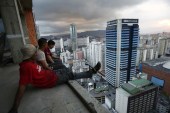 Men rest after salvaging metal on the 30th floor of a skyscraper 'slum' in Venezuela's capital, Caracas [Jorge Silva/Reuters]