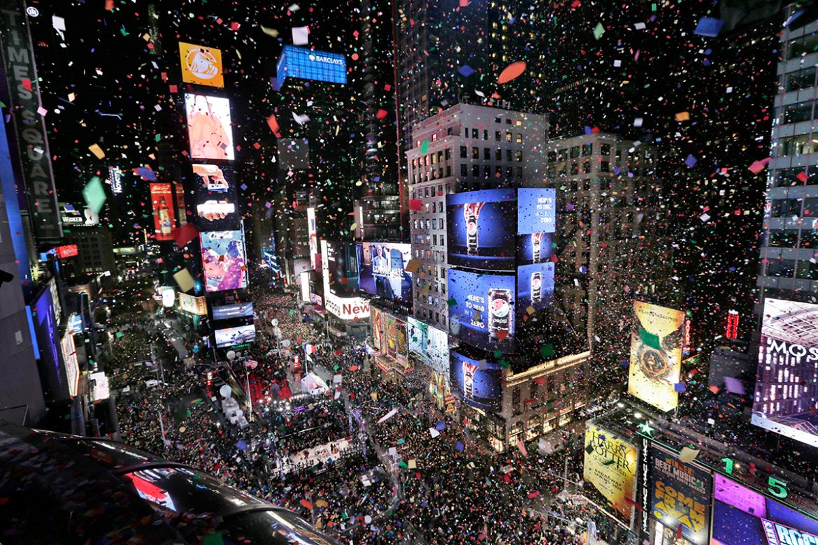 Confetti drops over the crowd as the clock strikes midnight during the New Year''s celebration in Times Square as seen from the Marriott Marquis in New York, Monday, Jan. 1, 2018. (AP Photo/Seth Wenig)