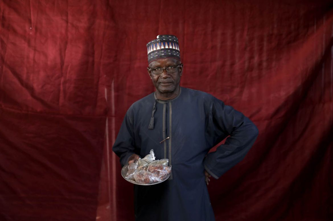 Jibril Adamu holds okra seeds and sugared groundnuts, ready for exchange. REUTERS/Afolabi Sotunde