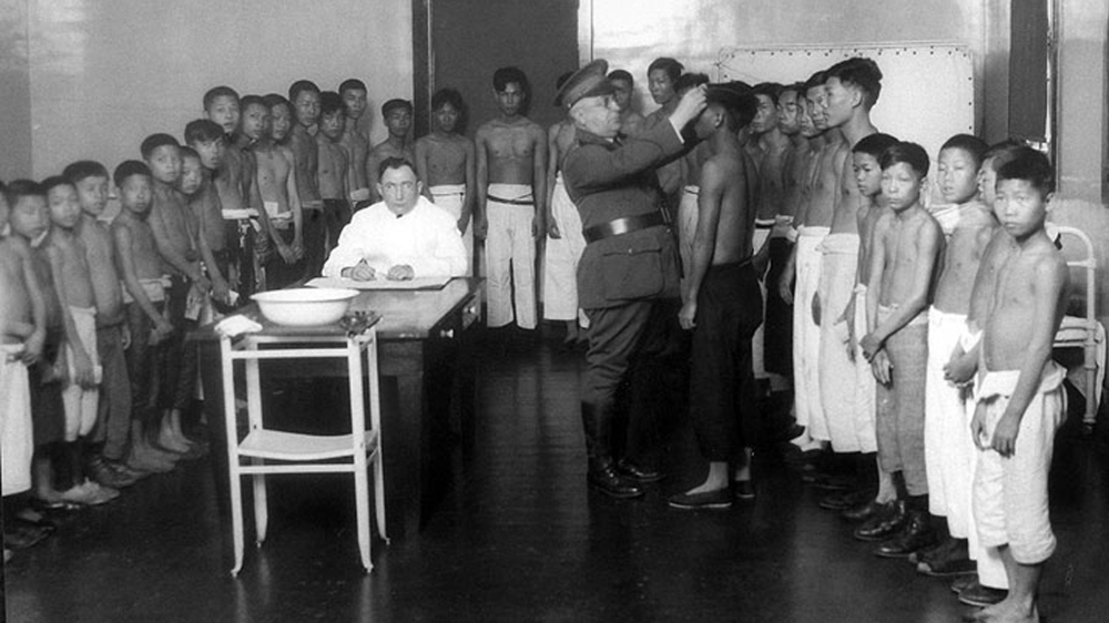 Immigration officials medically examine Chinese boys detained at Angel Island in San Francisco Bay [FoundSF/National Archive] 