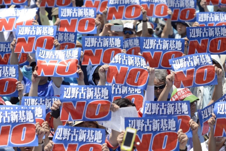 Protesters raise placards during a rally to oppose the transfer of a key U.S. military base within the prefecture, at a baseball stadium in the prefectural capital Naha on Japan''s southern island of O