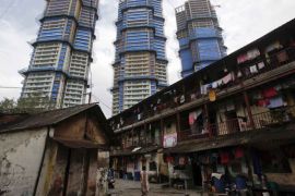 High-rise residential towers under construction are pictured behind an old residential building in central Mumbai [Vivek Prakash/Reuters]