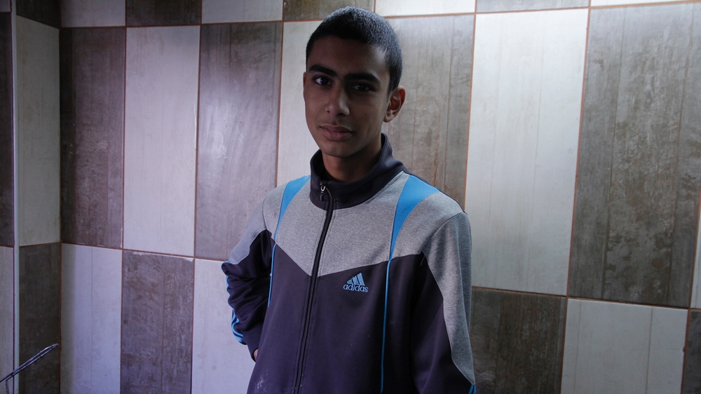 Yazan Muhammad Sabri works at his family's falafel shop in the camp [Ibrahim Husseini/Al Jazeera]