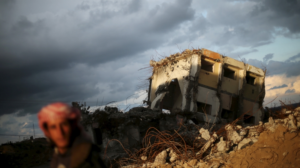A Palestinian man looks on as he stands near a house destroyed during 2014 war [Mohammed Salem/Reuters]