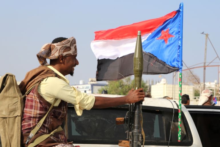 Bodyguard of a southern Yemeni separatist leader holds an RPG launcher as he rides on the back of a pick-up truck at the site of an anti-government protest in Aden