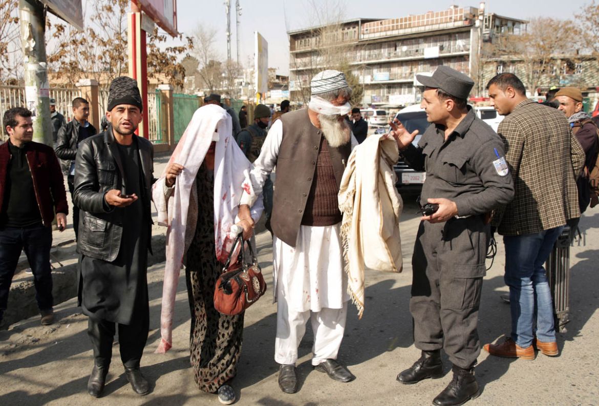 A wounded elderly couple speak to police at the site of a deadly suicide attack in the center of Kabul, Afghanistan, Saturday, Jan. 27, 2018. Afghan Public Health Ministry says dozens have been killed