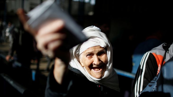 Palestinian refugee woman gestures as she waits to receive aid at UN food distribution centre in Al-Shati refugee camp in Gaza City