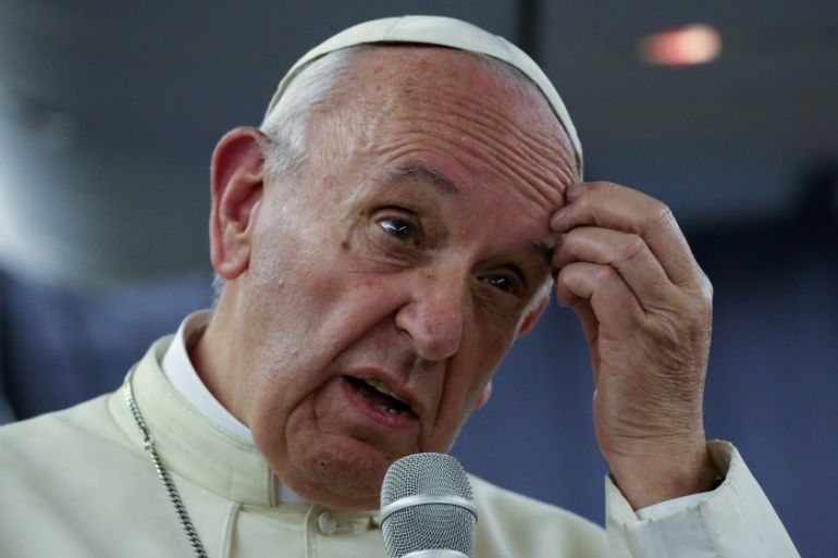 Pope Francis gestures during a news conference on board the plane during his flight back from a trip to Chile and Peru