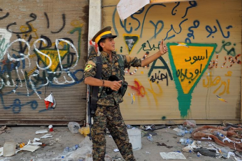 A people protection unit (YPG) fighter takes a selfie in the old city of Raqqa