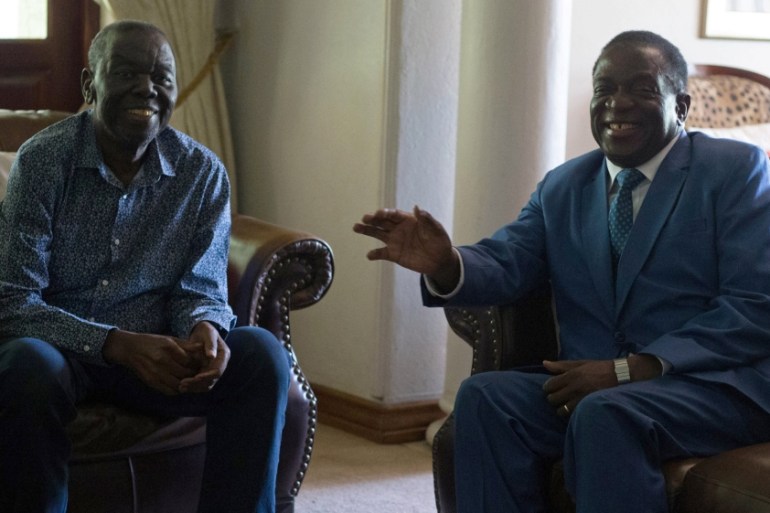 Zimbabwean President Emmerson Mnangagwa chats during his visit to opposition leader Morgan Tsvangirai at his house in Harare