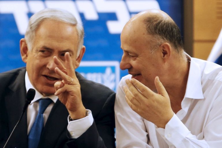 Israel''s Prime Minister Netanyahu chats with the coalition chairman Hanegbi as they attend a meeting of the Likud party in the Israeli parliament in Jerusalem