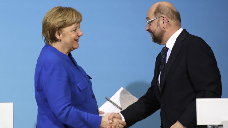 German Chancellor Angela Merkel, left, shakes hand with Social Democratic Party Chairman Martin Schulz