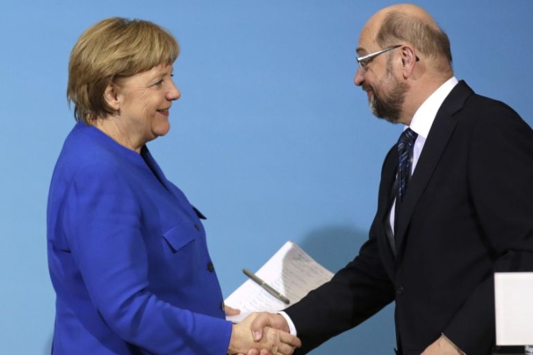 German Chancellor Angela Merkel, left, shakes hand with Social Democratic Party Chairman Martin Schulz