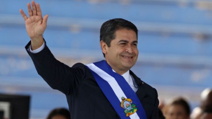 Honduran President Juan Orlando Hernandez waves after receiving the presidential sash for a new term during his inauguration at the Tiburcio Carias Andino National Stadium in Tegucigalpa