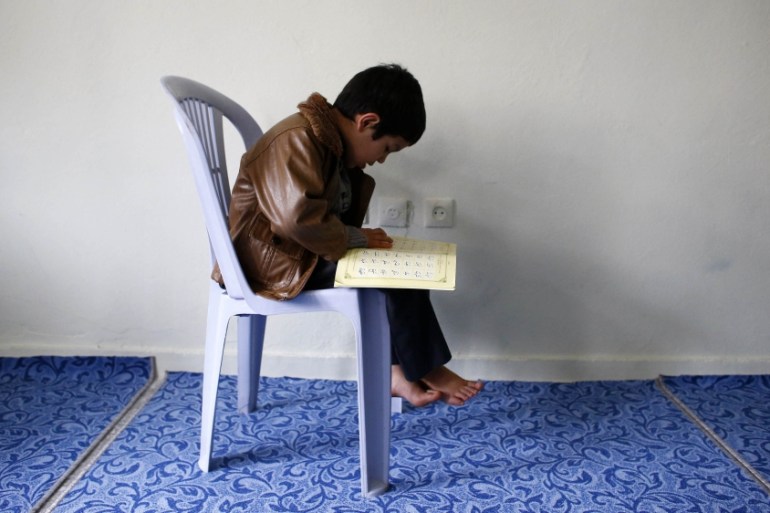 An Uighur refugee boy reads the Koran where he is housed in a gated complex in the central city of Kayseri, Turkey