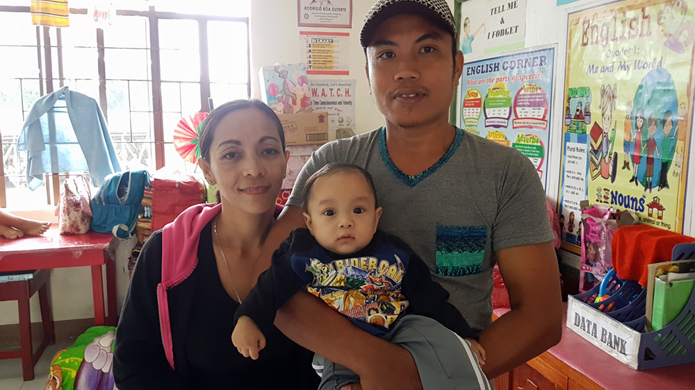 Divina and Rommel Miranda with their 6-month-old son, Aaron [JC Gotinga/Al Jazeera]