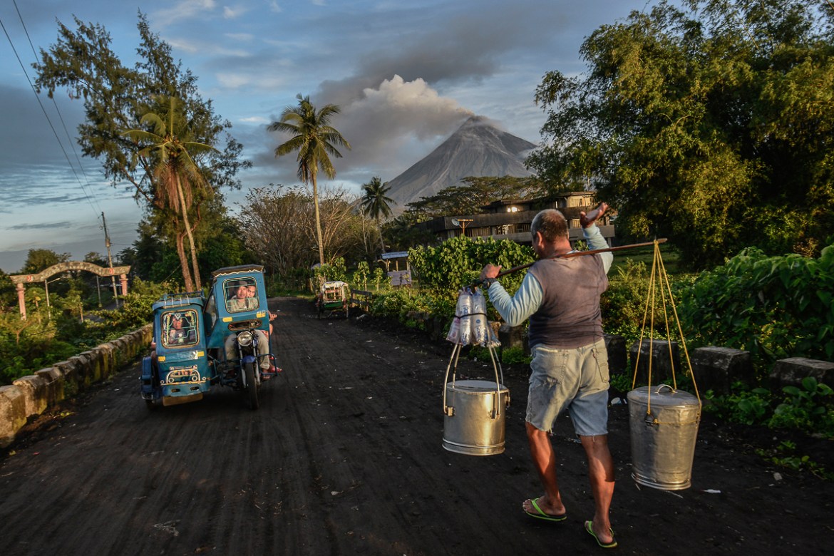 Residents go about daily life as Mount Mayon makes a mild eruption as seen from Daraga, Albay province, Philippines, January 25, 2018.