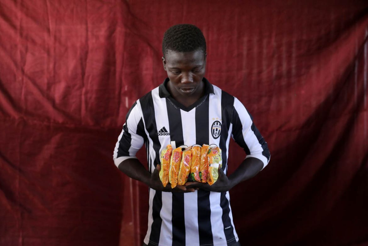 Abachi Mohammed holds six packets of chicken instant noodles. REUTERS/Afolabi Sotunde