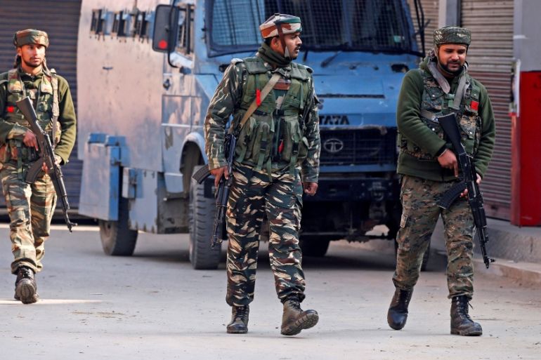 Indian policemen patrol a street after an explosion where according to local media four policemen died when suspected militants set off an improvised explosive device at a market in Sopore