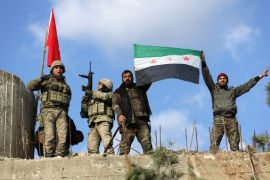 Turkish forces and Free Syrian Army members hold flags on Mount Barsaya