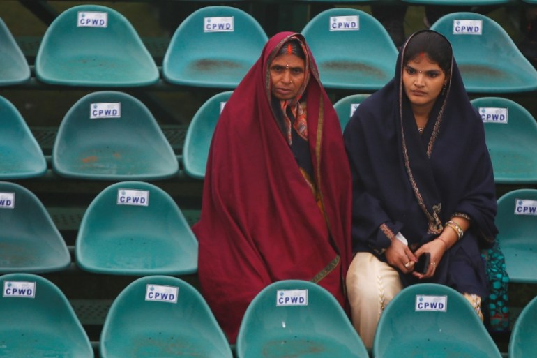 Women wrap themselves in shawls as they wait for the Republic Day parade to start in New Delhi