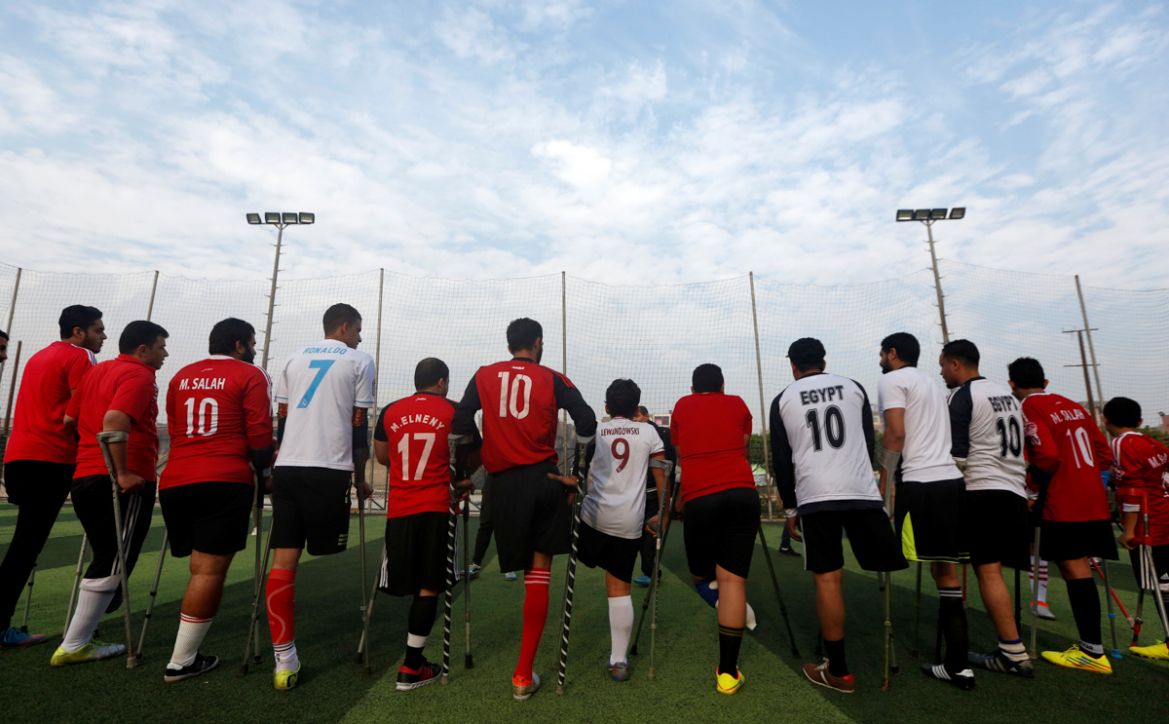Members of "Miracle Team", a soccer team made up of one-legged, crutch-bearing soccer players, listen to their coach before a training session at El Salam club on the outskirts of Cairo, Egypt Decembe