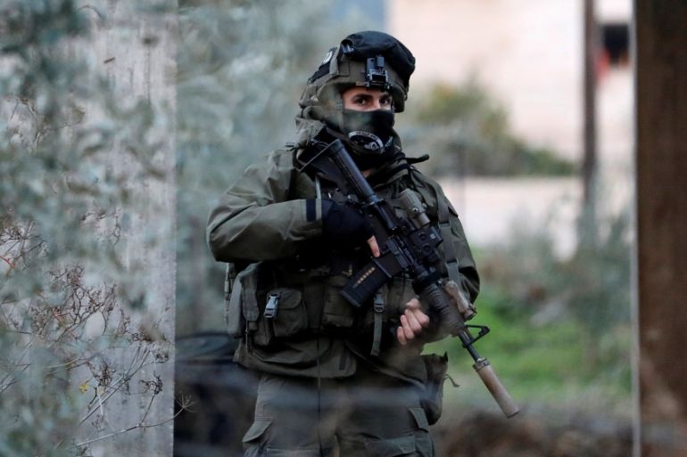 Member of Israeli armed forces is seen during a raid in the West Bank city of Jenin
